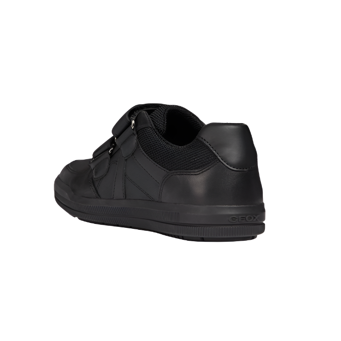 Black leather and mesh velcro school shoe, rear side view, rubber sole, closed heel.
