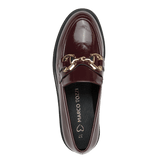 A single dark burgundy patent leather loafer by Marco Tozzi, featuring a gold horsebit detail across the vamp, shown from a top-down view against a solid green background.