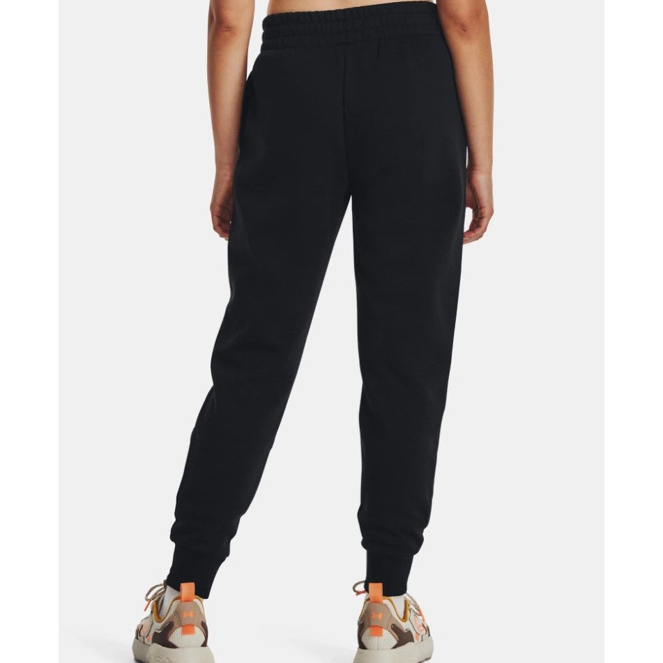 Back view of a person wearing black jogger sweatpants and beige sneakers