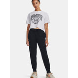 Woman in white cropped graphic t-shirt, black joggers, and sneakers, standing studio